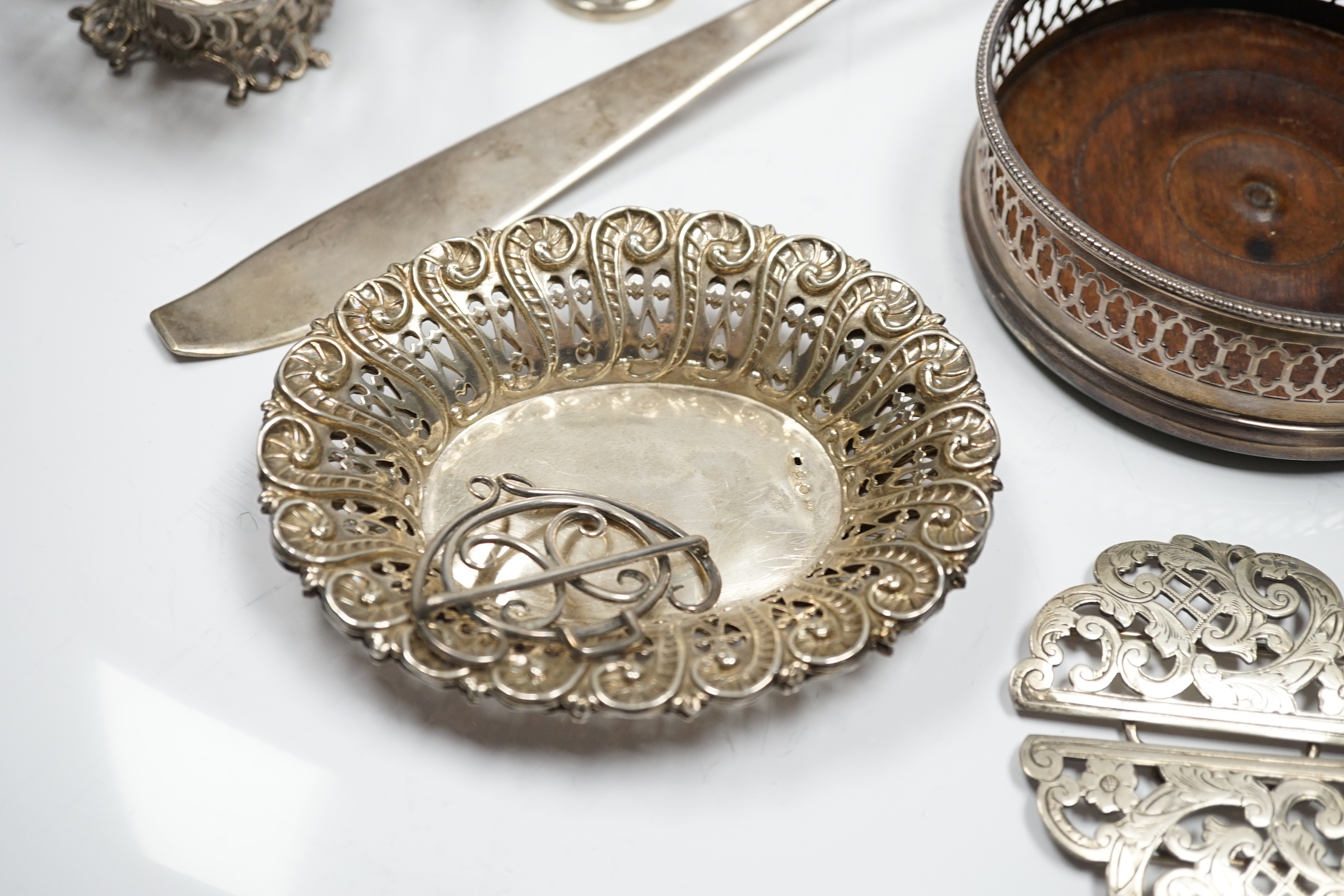Assorted silver and white metal items including a pair of late Victorian pierced silver bonbon dishes, a pierced silver small bowl, a modern silver wine coaster, a silver belt buckle, white metal belt buckle, two contine